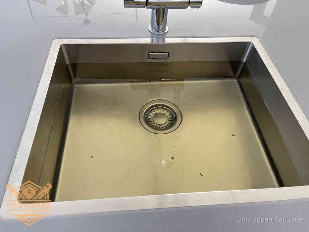 Stilstaand water in een rvs spoelbak dat niet wegloopt, een duidelijk signaal van een gootsteenverstopping in Kerkrade