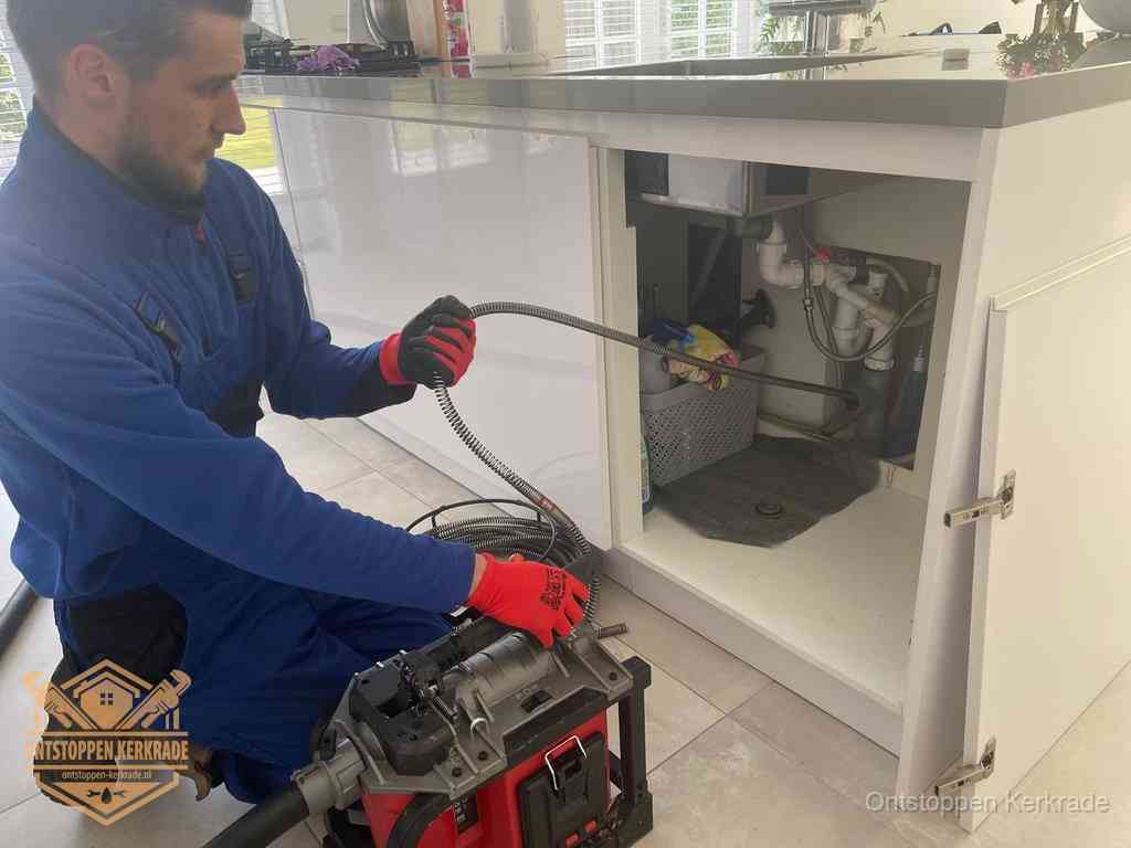 Een monteur reinigt de keukenafvoer grondig met een veermachine om terugkerende gootsteenverstoppingen te voorkomen in Kerkrade