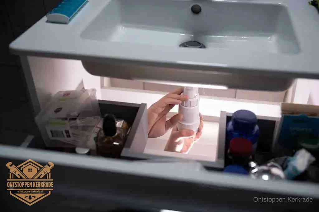Een pompfles met zeep boven een wastafel in de toiletruimte, de warm water en afwasmiddel-methode om de wc te ontstoppen in Kerkrade